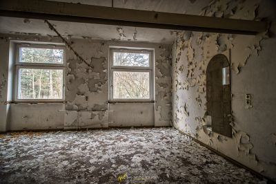 Ein Raum mit einem Fenster und einer Wand mit schälender Farbe