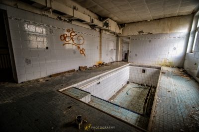 Ein Badezimmer mit einer gebrochenen Wanne und Graffiti an den Wänden