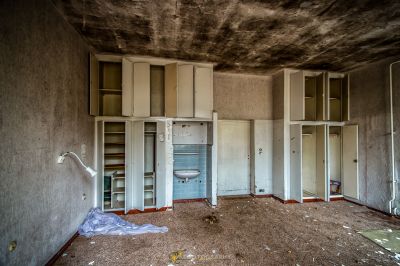 Ein Zimmer mit vielen Trümmern und einem kaputten Kühlschrank