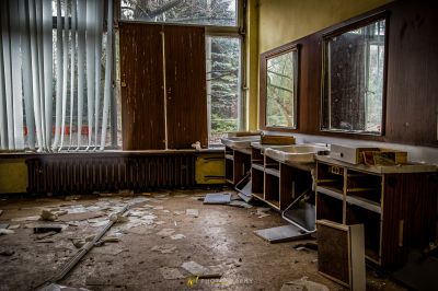 Ein Zimmer mit einem Schreibtisch und einem Fenster