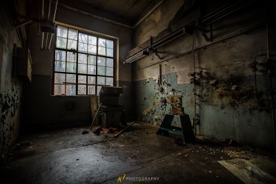 Ein Zimmer mit einem kaputten Fenster und einem kaputten Stuhl