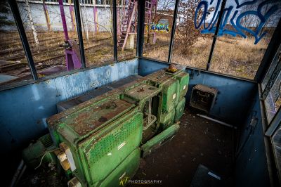 Eine grüne Box, die in einem Raum mit Graffiti an den Wänden sitzt