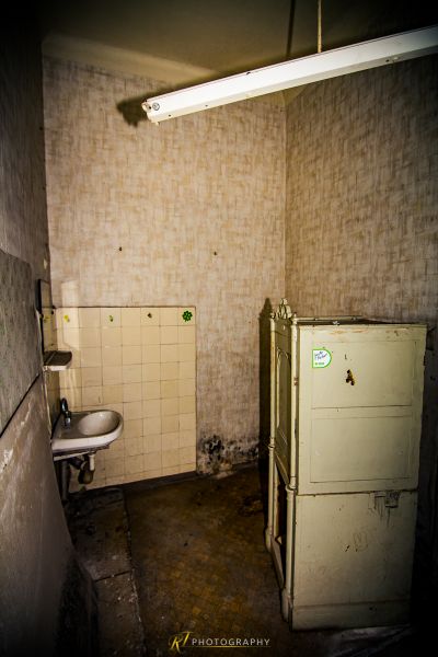 Ein schmutziges Badezimmer mit Waschbecken und Kühlschrank