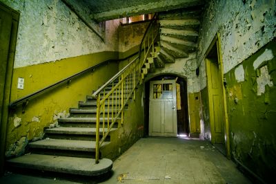 Eine Treppe in einem alten Gebäude mit schälender Farbe