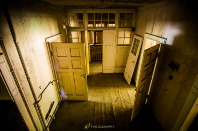 Ein Zimmer mit einem Haufen Türen und einem Fenster