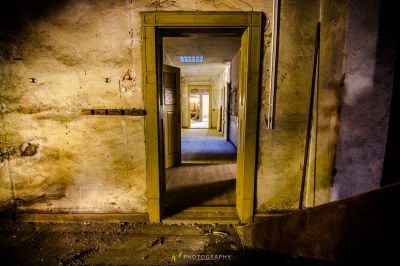 Eine Tür, die zu einem Flur in einem alten Gebäude führt