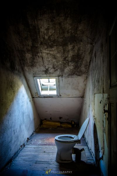 Eine Toilette in einem schmutzigen Raum mit einem Fenster