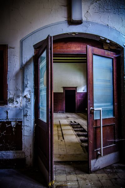 Eine Tür mit geöffneter Tür in einem heruntergekommenen Gebäude