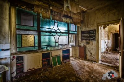 Eine Küche mit einem kaputten Fenster und einem Waschbecken