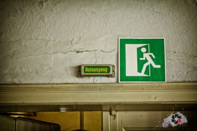 Ein grünes Schild an einer weißen Wand