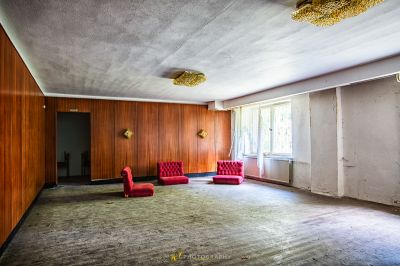 Ein Zimmer mit einem roten Stuhl und einem roten Stuhl