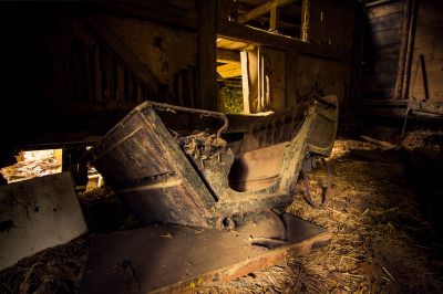 Ein kaputtes altes Auto in einer Scheune