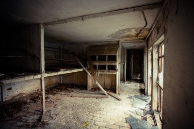 Ein Zimmer mit einer kaputten Decke und einer kaputten Tür