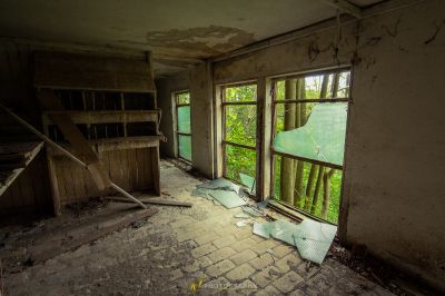 Ein Zimmer mit einem kaputten Fenster und einer kaputten Tür