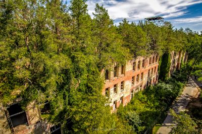 Ein großes Gebäude umgeben von Bäumen und einem Hubschrauber