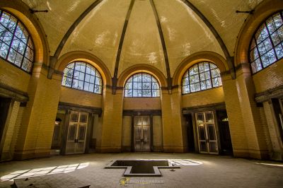 Ein großer Raum mit einem großen Fenster und einem kleinen quadratischen Boden