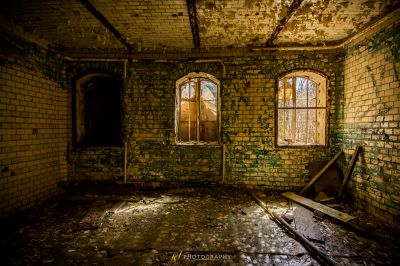 Ein Zimmer mit einem kaputten Fenster und einem kaputten Stuhl