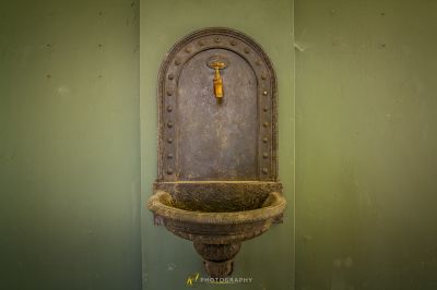 Eine Mauer mit einem Wasserbrunnen darin