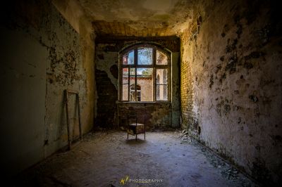 Ein Stuhl in einem Zimmer mit Fenster