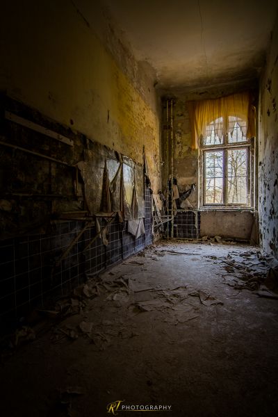 Ein Zimmer mit einem kaputten Fenster und einem kaputten Stuhl