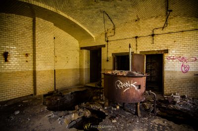 Ein Zimmer mit Mülleimer und Graffiti an der Wand