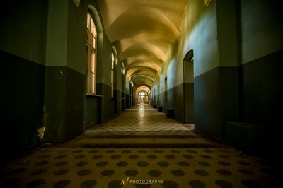 Einen langen Flur mit einem gefliesten Boden und einer langen Decke