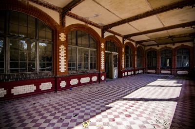 Ein großes Zimmer mit einem karierten Boden und einem großen Fenster