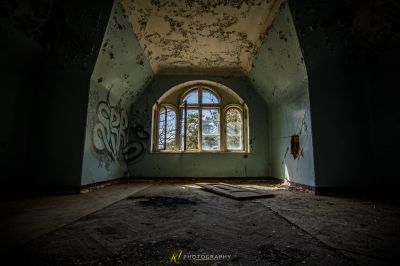 Ein Raum mit einem Fenster und Graffiti an den Wänden