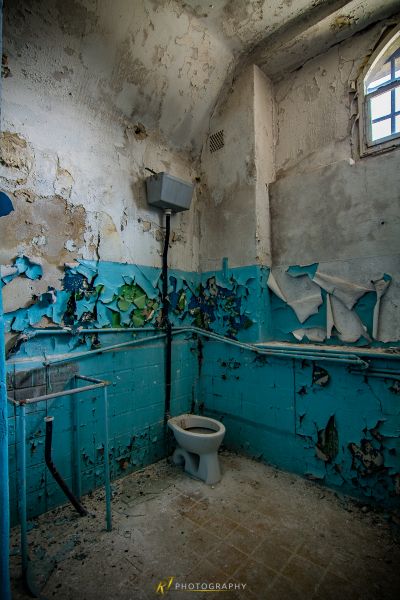 Ein Badezimmer mit einer kaputten Toilette und einem kaputten Fenster