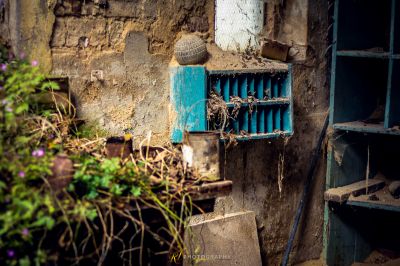 Eine blaue Tür mit einem Blumenstrauß darin