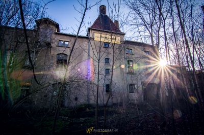 Ein Gebäude mit einer Sonne, die durch die Bäume scheint