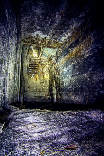 Ein dunkler Raum mit einer Treppe, die zu einem Keller führt