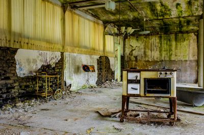 Eine schmutzige Küche in einem alten Gebäude mit einem kaputten Backofen