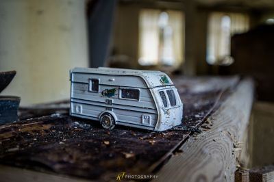 Ein Spielzeug rv sitzt auf einem Stück Holz