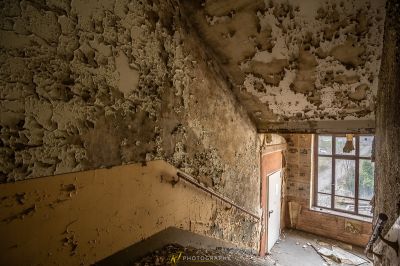 Ein Zimmer mit einer zerbrochenen Decke und einem Fenster