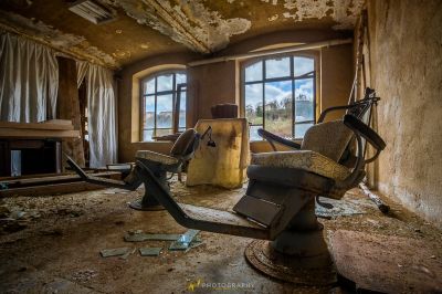 Ein Zimmer mit einem kaputten Stuhl und einem kaputten Fenster