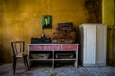 Ein Zimmer mit einem Stuhl, einem Schrank und einem Gemälde