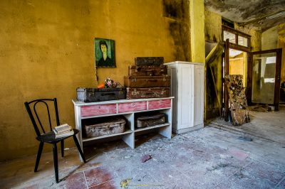 Ein Zimmer mit einem Stuhl, einem Schrank und einem Gemälde