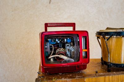 Ein roter Fernseher, der auf einem Holztisch sitzt