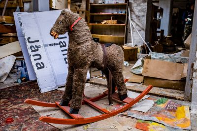 Ein Hund steht auf einem Schaukelpferd in einem Raum