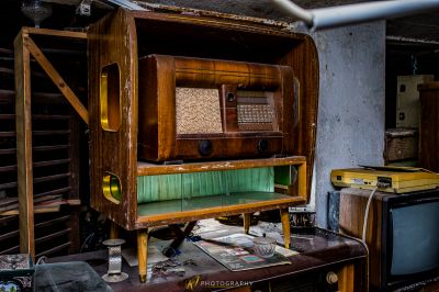 Ein Zimmer mit einem kaputten alten Radio und einem kaputten Fernseher