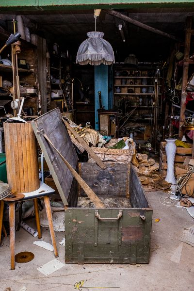 Ein Haufen Schrott in einer Garage mit einer grünen Box