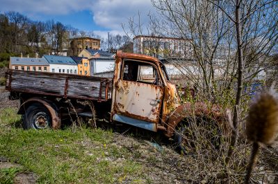 Ein verrosteter LKW sitzt in einem Feld