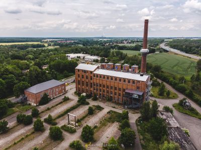 Ein großes Backsteingebäude, umgeben von Bäumen