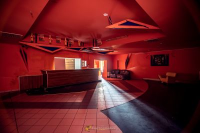 Ein Zimmer mit einer roten Wand und einem schwarzen Boden