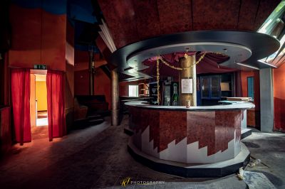 Eine Bar mit einem roten Vorhang und einer goldenen Statue