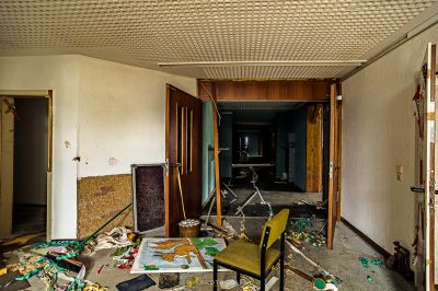 Ein Zimmer mit einem Stuhl und einem Tisch mit Schrott bedeckt