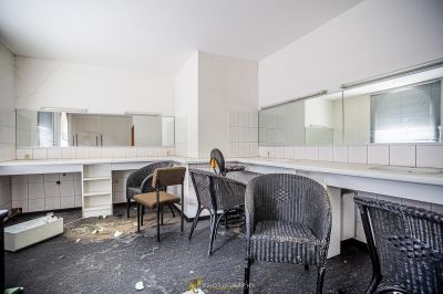 Ein Badezimmer mit Stuhl und Spiegel