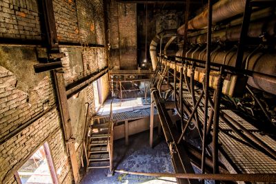 Ein Zimmer mit einem Haufen Pfeifen und einem Stuhl