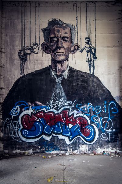 Ein Mann mit Schnurrbart und einem Anzug an der Wand